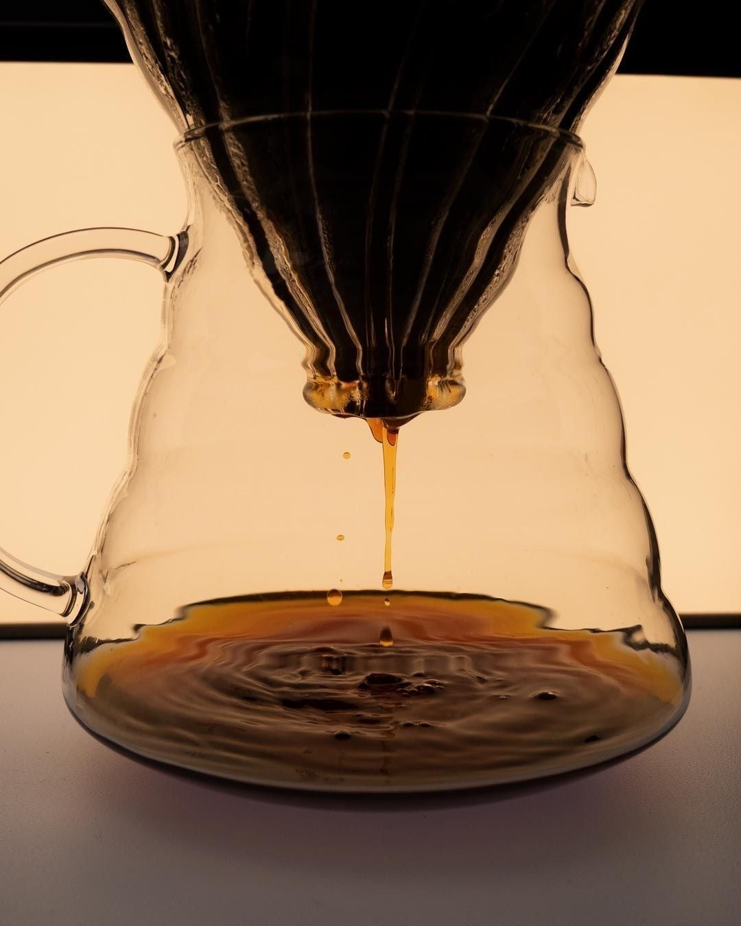 Pour-over coffee dripping into a glass server.